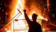 TOPSHOT - A protester raises a fist near a fire during a demonstration outside the White House over the death of George Floyd at the hands of Minneapolis Police in Washington, DC, on May 31, 2020.  / AFP / Samuel Corum
