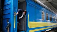 A conductor cleans handrails of a train upon the arrival at the central railway station, after train services were resumed as part of another stage to ease the coronavirus disease (COVID-19) restrictions in Kiev, Ukraine June 1, 2020. REUTERS/Gleb Garanic