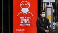 A man wearing a mask waits at a bus stop in London, following the outbreak of the coronavirus disease (COVID-19), London, Britain, June 5, 2020. REUTERS/Toby Melville