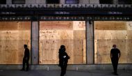 Security guards stand outside Saks Fifth Avenue after the 8 p.m. curfew continued Saturday night in response to looting during the Black Lives Matter's protests in the Manhattan borough of New York City, U.S., June 6, 2020. REUTERS/Andrew Kelly