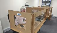 Staff at Pallite work at their desks while protected from colleagues by the company’s cardboard social distancing screens, following the outbreak of the coronavirus disease (COVID-19), at their HQ in Wellingborough, Britain May 27, 2020. REUTERS/Stuart Mc