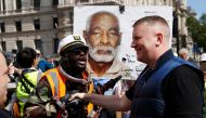 A demonstrator shakes hands with Paul Goulding, leader of a far-right political group Britain First, as they speak ahead of a Black Lives Matter protest following the death of George Floyd in Minneapolis police custody, in London, Britain, June 13, 2020. 