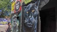 Graffiti artist Moises Frank walks past the Graffiti Alley, in Toronto, on June 12, 2020. AFP / Olivier Monnier 