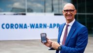 Timotheus Hoettges, CEO of Germany's telecommunications giant Deutsche Telekom AG, holds a mobile phone as he attends the presentation of the new contact-tracing smartphone app in Berlin, Germany, June 16, 2020. REUTERS/Hannibal Hanschke/Pool