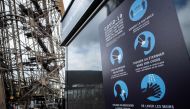 Sanitary instructions are seen on the waiting line to the Eiffel Tower, on June 15, 2020 in Paris, ahead of the partial reopening of the monument to the public as France eases lockdown measures taken to curb the spread of the Covid-19 pandemic (novel coro