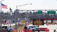 :(FILES) In this file photo taken on March 22, 2020 US Customs officers stand beside a sign saying that the US border is closed at the US/Canada border in Lansdowne, Ontario. Ottawa and Washington are in talks to extend the closure of the Canada-US border
