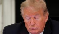 U.S. President Donald Trump taps the screen on a mobile phone at the approximate time a tweet was released from his Twitter account, during a roundtable discussion on the reopening of small businesses in the State Dining Room at the White House in Washing