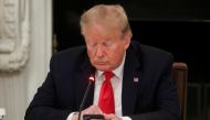 U.S. President Donald Trump uses a mobile phone during a roundtable discussion on the reopening of small businesses in the State Dining Room at the White House in Washington, U.S., June 18, 2020. REUTERS/Leah Millis 