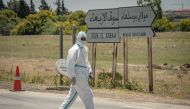 A member of the medical staff walks around during his break in the town of Moulay Bousselham, north of the capital Rabat, on June 20, 2020, as authorities received around 700 COVID-19 patients. / AFP / FADEL SENNA