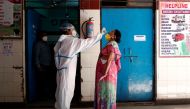 A medical worker collects a sample from a woman at a school turned into a centre to conduct tests for the coronavirus disease (COVID-19), amidst its spread in New Delhi, India June 22, 2020. REUTERS/Adnan Abidi
