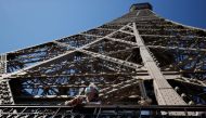 A visitor wearing a protective face mask admires the view from the Eiffel Tower during its partial reopening on June 25, 2020, in Paris. AFP / Thomas SAMSON
