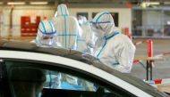 Medical personnel talk to a person at a drive-in testing site at an out-of-service aircraft hangar at Guetersloh Airport following an outbreak of the coronavirus disease (COVID-19) in Guetersloh, Germany, Germany June 27, 2020. REUTERS/Leon Kuegeler