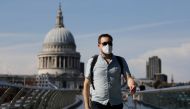 A pedestrian walks over The Millennium Bridge away from St Paul's Cathedral in London on June 26, 2020, as temperatures are expected to again be high, hitting 31 degrees Celsius in London. AFP / Tolga AKMEN