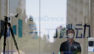 A security guard, wearing a face mask following the coronavirus disease (COVID-19) outbreak, stands near a surveillance camera at an office of Bytedance, the China-based company which owns the short video app TikTok, or Douyin, in Beijing, China July 7, 2