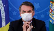 In this file photo taken on March 18, 2020 Brazilian President Jair Bolsonaro gestures using a face cover during a press conference regarding the COVID-19, coronavirus pandemic at the Planalto Palace, Brasilia. / AFP / Sergio LIMA