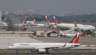 An aircraft of Philippines Airlines (PAL), the Southeast Asian nation's flag carrier, taxiing at a runway while other aircraft park besides the hangar of the Ninoy Aquino International Airport (NAIA) in Manila March 14, 2016. REUTERS/Romeo Ranoco/File Pho