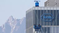 FILE PHOTO: The peak of Mount Pilatus is seen in the background as workers clean the windows of a building of Roche in Rotkreuz May 27, 2020. REUTERS/Arnd Wiegmann 