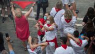 Revellers wearing face masks attend symbolic celebrations for the suspended 'Chupinazo' opening ceremony to mark what was supposed to be the kick-off of the San Fermin Festival outside the Town Hall of Pamplona in northern Spain on July 6, 2020. / AFP / A