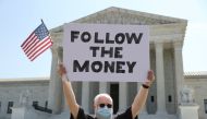 Bill Christeson holds a sign reading 