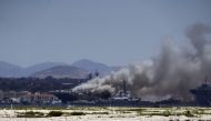 Smoke rises from a fire on board the U.S. Navy amphibious assault ship USS Bonhomme Richard at Naval Base San Diego, as seen from Coronado, California, U.S. July 12, 2020. REUTERS/Bing Guan
