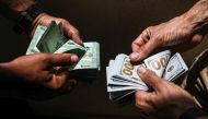 (FILES) In this file photo taken on June 18, 2020, people exchange Lebanese pound and US dollar notes on the black market in Lebanon's capital Beirut. AFP / JOSEPH EID