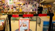 (FILES) In this file photo a sign with a facemask promoting COVID-19 safety measures is seen in a store in Miami Beach, Florida on June 16, 2020./ AFP / Eva Marie UZCATEGUI