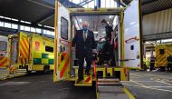 Britain's Prime Minister Boris Johnson (L), wearing a face mask or covering due to the COVID-19 pandemic, talks with a paramedic inside the back of an ambulance during his visit to the headquarters of the London Ambulance Service NHS Trust in central Lond