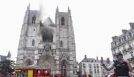 A French Police officer gestures as firefighters are at work to put out a fire at the Saint-Pierre-et-Saint-Paul cathedral in Nantes, western France, on July 18, 2020. AFP / Sebastien Salom-Gomis 