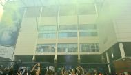 Leeds United players at a window inside the stadium gesture to supporters gathering outside their Elland Road ground to celebrate the club's return to the Premier League after a gap of 16 years, in Leeds, northern England on July 17, 2020. Leeds United we