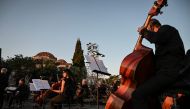 Members of the orchestra of the Greek National Opera prepares for a concert at the ancient Roman Agora in Athens on July 18, 2020. / AFP / Aris MESSINIS