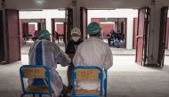 A doctor consults a patient before screening for COVID-19 coronavirus at the COVID-19 Medical Centre of Andohatapenaka in Antananarivo on July 20, 2020. / AFP / RIJASOLO