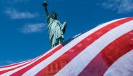 NEW YORK, NY - JULY 20: The Statue of Liberty is seen over a wind blown American flag scarf on Liberty Island on July 20, 2020 in New York City. Liberty Island partially reopens months after the attraction was shut down due to the coronavirus pandemic. Je