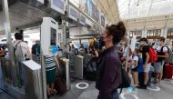 A traveller as her temperature checked at the security gate, prior to board a TGV high-speed train at the Gare de Lyon train station in Paris, on July 21, 2020, as part of sanitary measures taken to curb the spread of the COVID-19 pandemic, caused by the 