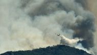 A firefighting plane makes a water drop as a wildfire burns near the village of Kechries, Greece, July 22, 2020. REUTERS/Vassilis Triandafyllou 