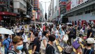 Pedestrians walk across a main road in Hong Kong on July 20, 2020. / AFP / ANTHONY WALLACE