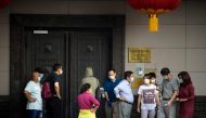 People attempt to talk to someone at the Chinese consulate in Houston on July 22, 2020. US-Chinese tensions, already rising because of the coronavirus pandemic and crackdown in Hong Kong, ratcheted up another notch on Wednesday as the US ordered the closu