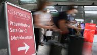 FILE PHOTO: Travellers rush past the entry of Germany's first walk-through the coronavirus disease (COVID-19) test center which is opened by diagnostics provider Centogene in cooperation with air carrier Lufthansa and Fraport at the airport in Frankfurt, 