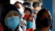 Passengers wearing protective face masks queue for a public bus, following the coronavirus disease (COVID-19) outbreak, at a central bus spot in Jakarta, Indonesia, July 27, 2020. REUTERS/Willy Kurniawan