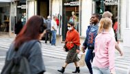 FILE PHOTO: A woman wearing a protective face mask, due to the coronavirus outbreak, walks in downtown Lisbon, Portugal March 12, 2020. REUTERS/Rafael Marchante
