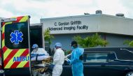 FILE PHOTO: Emergency Medical Technicians (EMT) arrive with a patient while a funeral car begins to depart at North Shore Medical Center where coronavirus disease (COVID-19) patients are treated, in Miami, Florida, U.S. July 14, 2020. REUTERS/Maria Alejan