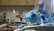A nurse cares for a coronavirus (COVID-19) patient in the Intensive Care Unit (ICU) at El Centro Regional Medical Center in hard-hit Imperial County on July 28, 2020 in El Centro, California.
