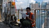 Kong, who works in construction, eats his takeaway lunch on a pavement in Hong Kong on July 29, 2020, after new social distancing measures came into effect which include restaurants only being allowed to serve takeaway meals, to combat a new wave of coron