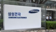 People walk past the logo of Samsung Electronics at the company's Seocho building in Seoul on July 30, 2020.  AFP / Jung Yeon-je