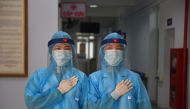 Health workers wearing protective clothes pose for a photo at a temporary testing centre for the COVID-19 coronavirus in Hanoi on July 30, 2020. Until the weekend it appeared that Vietnam had managed to stub out the virus -- and with lockdowns lifted sinc