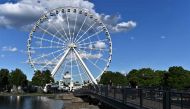 People take pictures in front of Ferris Wheel in the Old-Port, Montreal, Canada, on July 28, 2020. AFP / Eric Thomas 
 