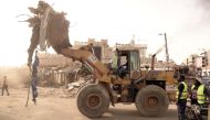 Caterpillars are seen in action at the start of the demolition work of the Sandaga market in Dakar, on August 2, 2020. / AFP / Seyllou