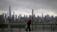 A man walks into heavy wind and rain along the waterfront of the Hudson River in front of the New York City skyline during Tropical Storm Isaias in Weehawken, New Jersey, U.S., August 4, 2020. REUTERS/Mike Segar TPX IMAGES OF THE DAY
