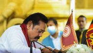 Sri Lanka's Prime Minister Mahinda Rajapaksa signs documents during his swearing-in ceremony at the sacred Kelaniya Raja Maha Buddhist temple, outside the capital Colombo on August 9, 2020.  / AFP / Ishara S. KODIKARA