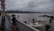 Pedestrians stand on a bridge as they look at a park inundated by flood water beside the Han river in Seoul on August 3, 2020. Heavy rain hit South Korea's central regions causing flooded houses and roads, Yonhap news agency reported, prompting authoritie
