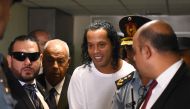(FILES) In this file photo taken on March 06, 2020, Brazilian retired football player Ronaldinho (C) arrives at Asuncion's Justice Palace to testify about his irregular entry to the country, in Asuncion. / AFP / Norberto DUARTE
